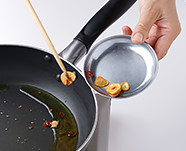 フライパンにオリーブ油、にんにく、唐辛子を入れて弱火にかける