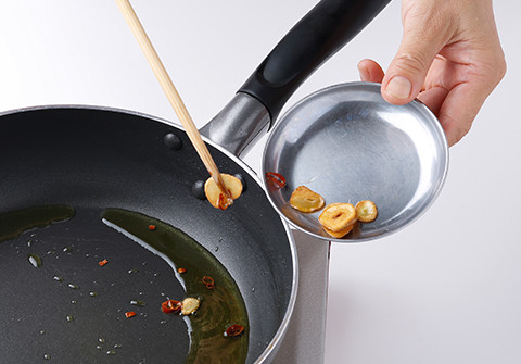 フライパンにオリーブ油、にんにく、唐辛子を入れて弱火にかける